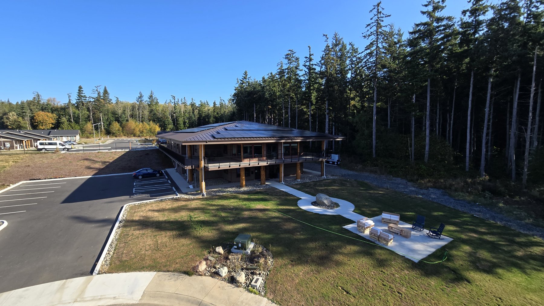 lummi-solar-site Wide view of the Lummi Elder Care Center, its grounds, parking area, and surrounding forest.